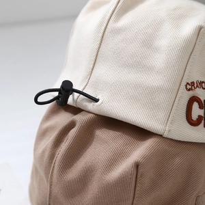 Detail of two-tone twill cotton kid hat with CRAYON embroidery and adjustable drawstring