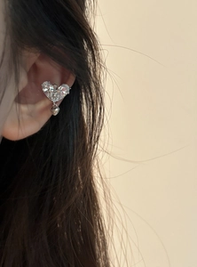 Detailed view of an elegant heart-shaped zircon ear cuff worn on the human ear