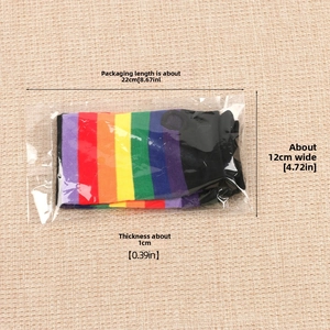 Rainbow striped stockings in protective clear plastic packaging on a textured beige backdrop