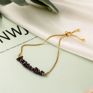 Detail of adjustable gold slider bracelet with deep red natural irregular stone beads
