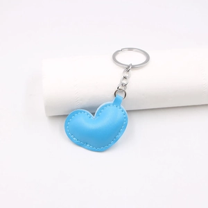 Detail of blue PU leather heart-shaped keychain with silver metal ring and fine stitching