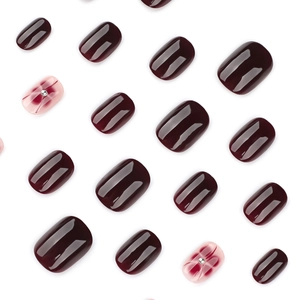 Short square burgundy false nails set with pink petal designs and silver bead accents