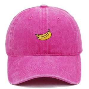 Close-up of yellow banana embroidery on a rose pink washed cotton baseball cap