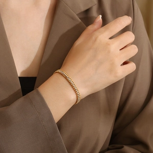 Elegante bracciale tennis dorato con zirconi trasparenti al polso di una modella