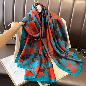 Floraler Satinschal mit orangen Blumen auf Schwarz für Strand und Sonnenschutz