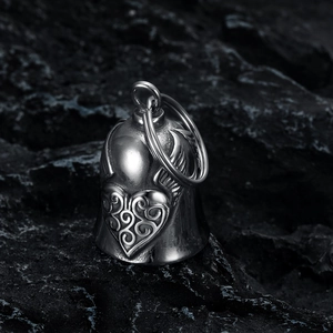 Macro detail of retro stainless steel guardian bell with heart and wing engravings