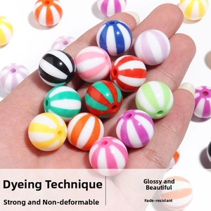 Macro shot of colorful striped acrylic candy beads held in hand for DIY jewelry making