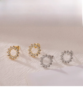 Détails de boucles d'oreilles rondes en zircon pavé doré et argenté sur lin