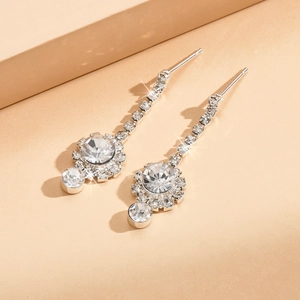 Détail de boucles d'oreilles de mariée argentées avec cristaux ronds étincelants
