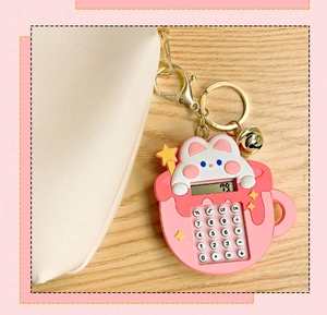Pink rabbit calculator keychain hanging on a beige bag over a wooden table detail
