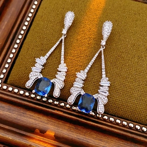 Macro view of vintage drop earrings with blue square stones and white zircon crystals
