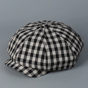 Detail of classic black and white checkered newsboy cap fabric and top button