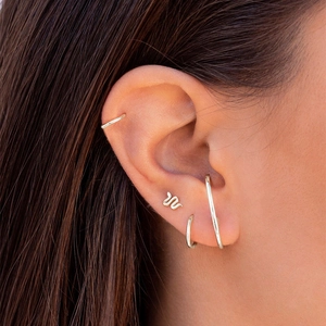 Detail shot of a 4-piece silver flower and snake stud earring set worn by a model