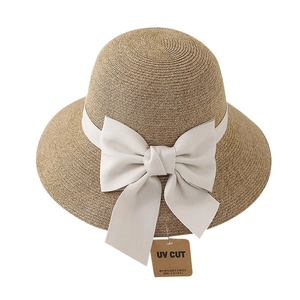 Straw sun hat for women with a cream bow and UV CUT tag on a white background