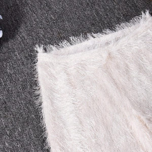 Gros plan sur la texture en fausse fourrure blanche douce du pantalon léopard