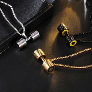 Close-up of stainless steel dumbbell pendants in gold, silver, and black with GO FIT engraving