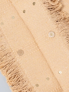 Large beige woven canvas tote bag with decorative fringe details and metal hardware accents
