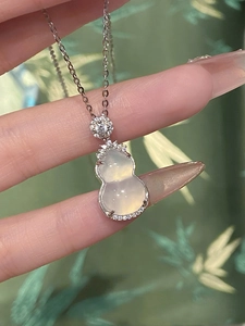 Detail shot of a silver stainless steel necklace with a white zircon gourd pendant