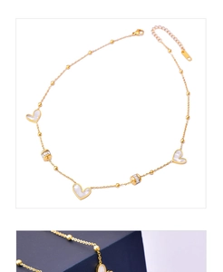 Detail of gold heart necklace featuring white shell inlay and sparkling zircon beads