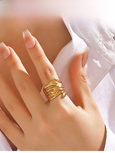 Detail of gold fluid lava ring with an irregular layered design on a model's hand