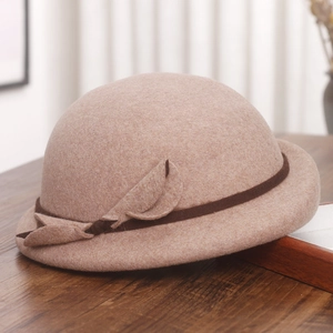 Close-up of wool felt bucket hat featuring a brown decorative band and leaf bow detail