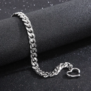 Detail view of 8mm silver Cuban chain bracelet with heart clasp on dark display stand