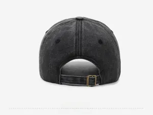Detail view of adjustable bronze buckle and washed grey fabric texture on baseball cap