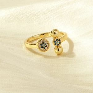 Detailed view of an 18K gold-plated X-shaped ring with blue and white zircon accents