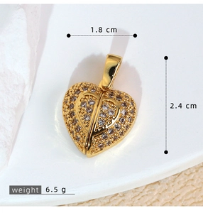 Macro detail of gold heart pendant with zircon wings, dimensions 1.8cm x 2.4cm