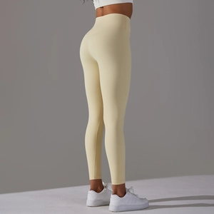 Detail view of high-waisted pale yellow yoga leggings with body-shaping stitch design