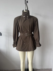 Détail du col montant et de la fermeture croisée sur ce trench-coat marron foncé