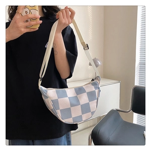 Detail of blue and white checkered crescent crossbody bag with adjustable wide strap