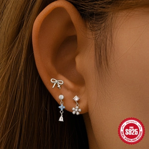 S925 sterling silver earring set with bow, flower and blue clover drop on female ear