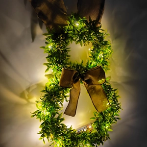 Gros plan d'une couronne de lapin verte avec oreilles en toile et lumières LED chaudes