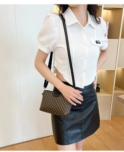 Brown monogram bucket bag with adjustable shoulder strap worn by a female model