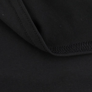 Close-up of black knit fabric texture with precision stitching and hem finish details