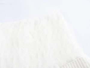 Detail eines weißen Low-Waist-Rocks mit Mesh-Lagen und plissierter Rüschensaum-Textur