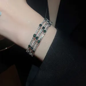 Three-layer wrap bangle with emerald-green stones and cubic zirconia in silver finish