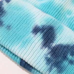 Detailed macro view of tie-dye rib-knit structure on the warm winter beanie hat fold