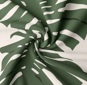 Detail eines tropischen Monstera-Blattdrucks auf weichem Stoff mit strukturierter Webart