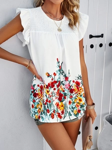 Detail of white sleeveless top with ruffle sleeves and colorful floral print at the hem