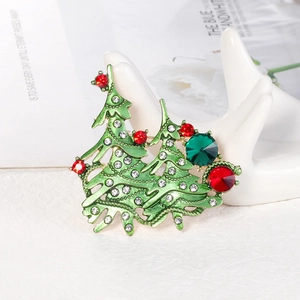 Elegant Christmas tree brooch with green enamel and rhinestones on a ceramic hand stand