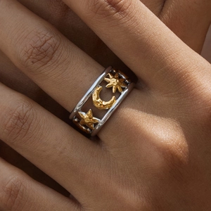 Detailed view of dual-tone stainless steel ring with hollow star and moon patterns