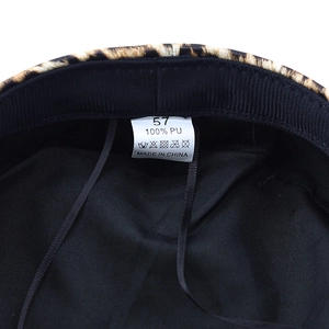 Detail view of the black inner lining and 100% PU material tag for leopard print hat
