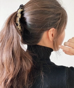 Close-up of tortoise shell banana clip holding a ponytail on a brunette model