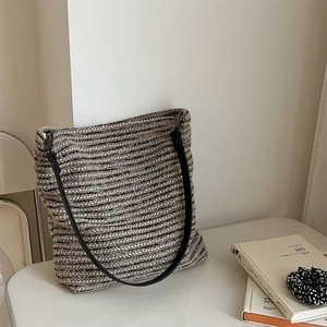Détail du sac cabas en tweed rayé avec bandoulière en cuir noir dans un décor minimaliste