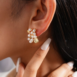 Detailed view of elegant gold leaf cluster earrings with multiple white pearls