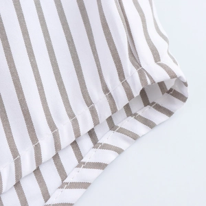 Vue détaillée du tissu en coton tissé à rayures beige et blanc avec coutures précises