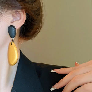 Irregular wooden teardrop earring worn on model for a minimalist artistic jewelry style