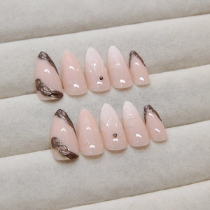 Almond press-on nails with nude pink gradient and 3D brown relief line patterns